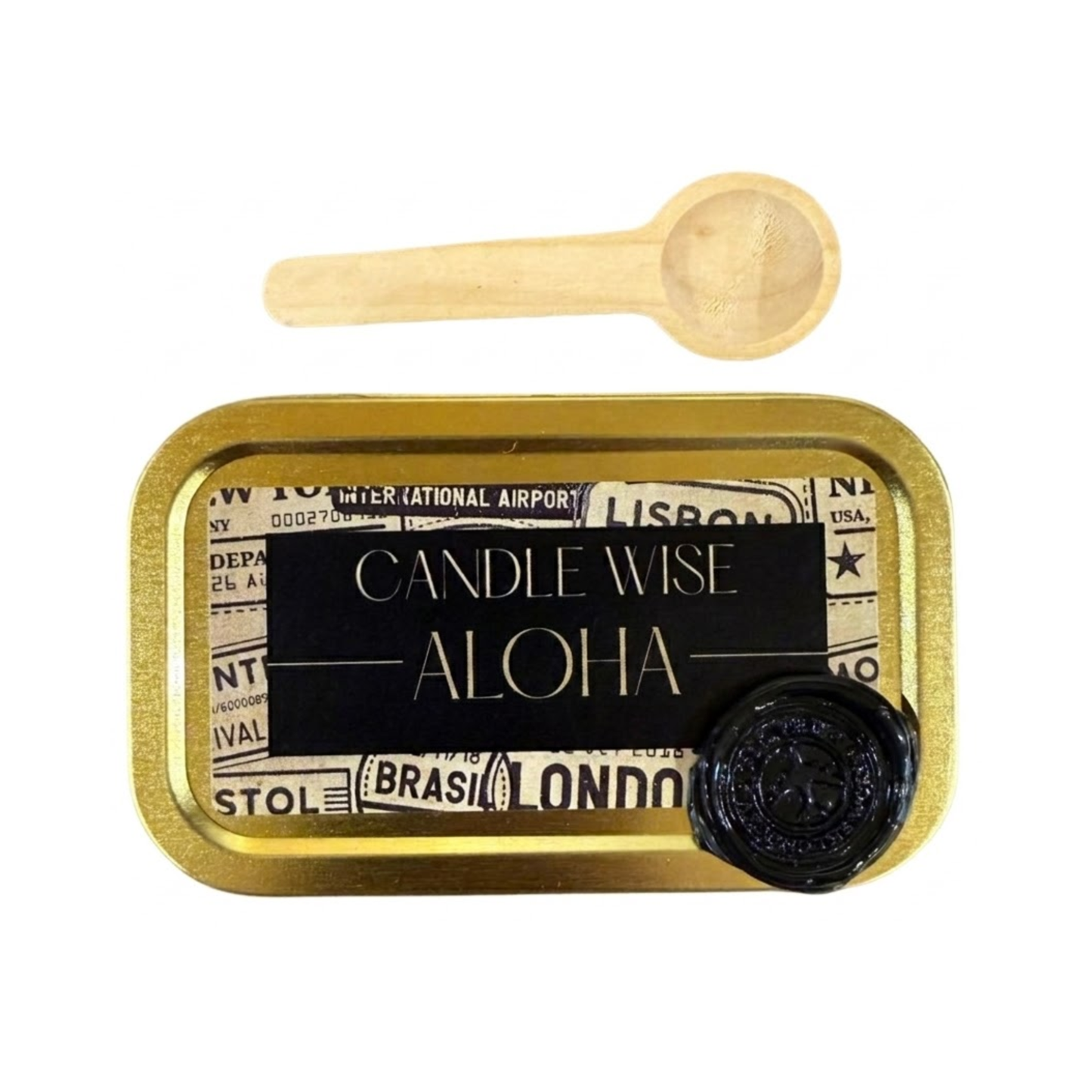 A top down view of a gold rectangular tin with a black and vintage travel themed label. The label features the text Candle Wise ALOHA in capital letters and a black wax seal. A small wooden scoop is placed above the tin.