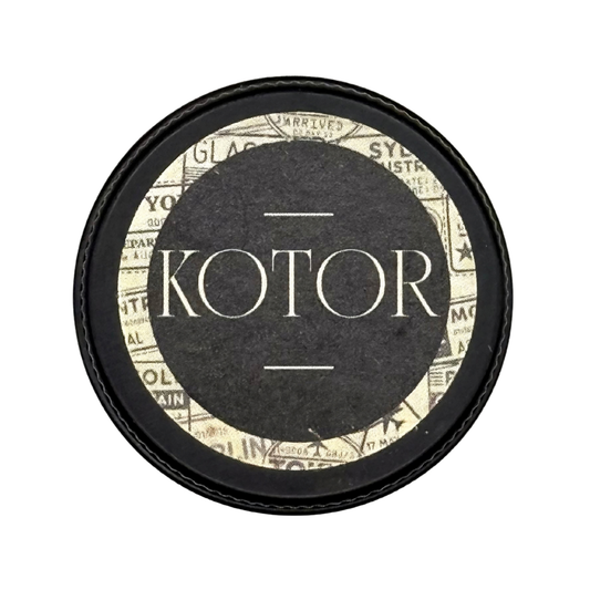 Candle Wise Kotor solid perfume closed black tin lid with travel stamp design.
