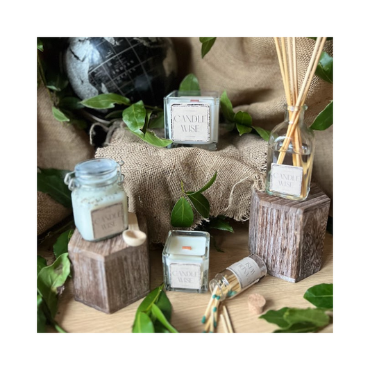 Candle Wise candles and reed diffuser styled on wooden blocks with greenery and a hessian backdrop