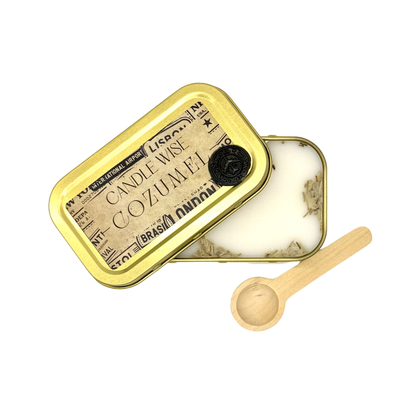 Candle Wise Cozumel scoopable wax melt open gold tin showing dried botanicals alongside lid and wooden spoon