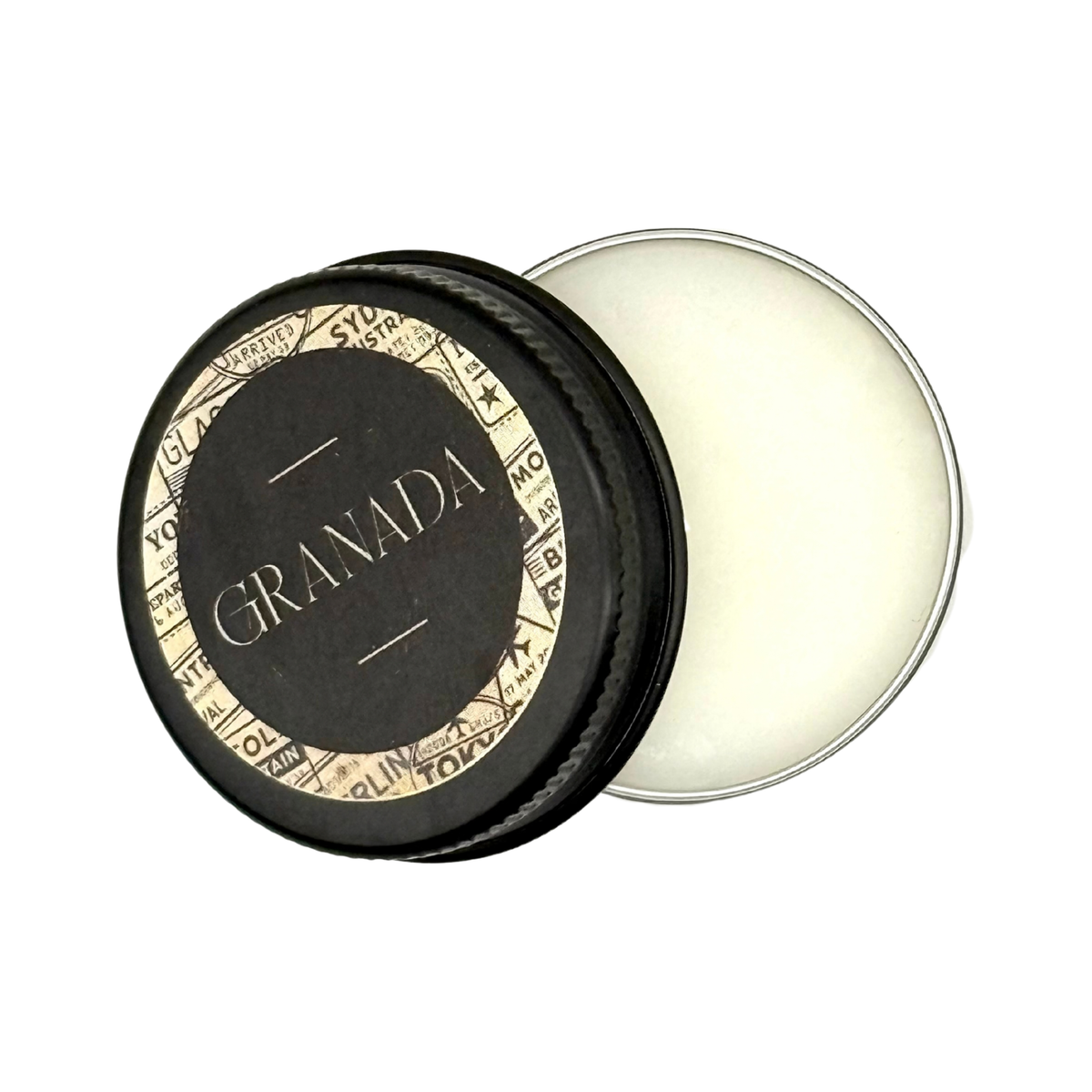 Candle Wise Granada solid perfume open black tin showing white balm with lid resting beside it.