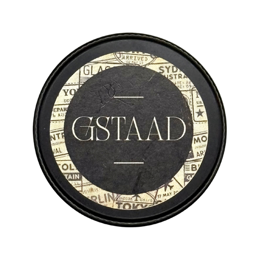 Candle Wise Gstaad solid perfume closed black tin lid featuring vintage travel label.