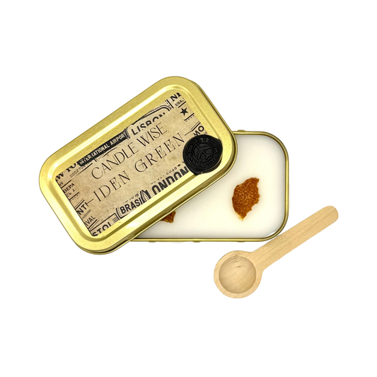 Candle Wise Iden Green scoopable wax melt open gold tin showing orange peel botanical toppings alongside lid and wooden spoon
