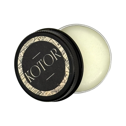 Candle Wise Kotor solid perfume open black tin showing white balm and lid.