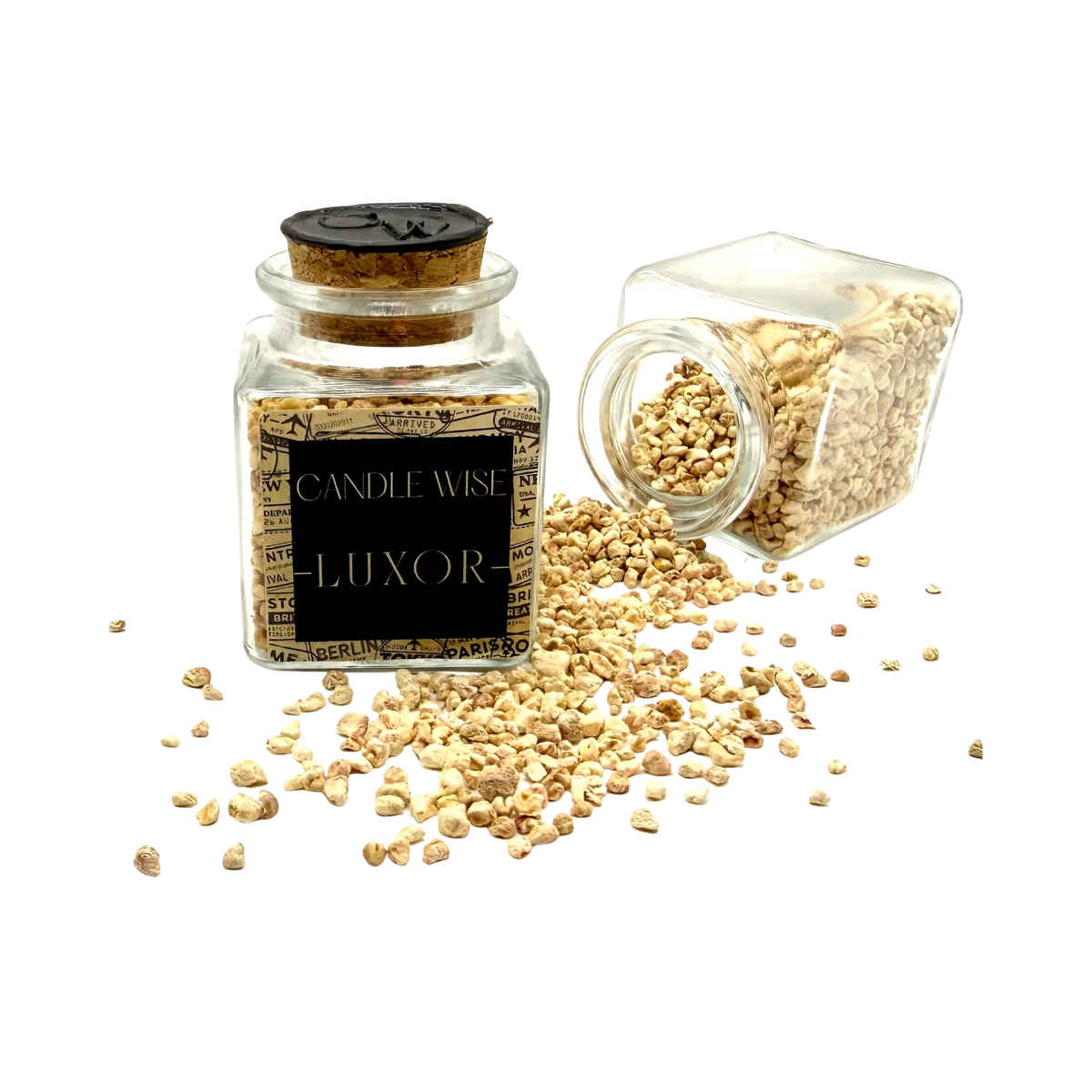 CANDLE WISE Luxor drawer diffuser glass jar standing beside an open tilted jar with scented corn cob granules spilling onto a clean background.