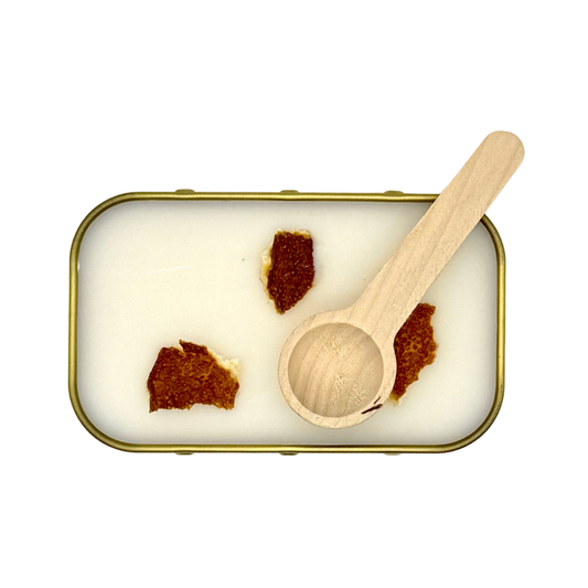 Overhead view of Candle Wise Iden Green scoopable wax melt showing dried orange peel toppings and wooden spoon